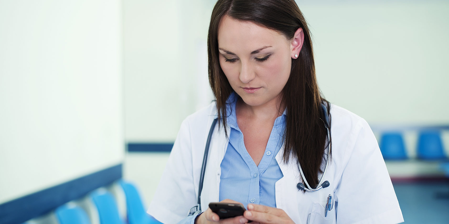 Young female doctor texting