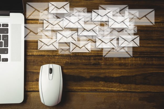 Composite image of laptop and mouse put on a desk with letter icons Is online faxing more secure than email?